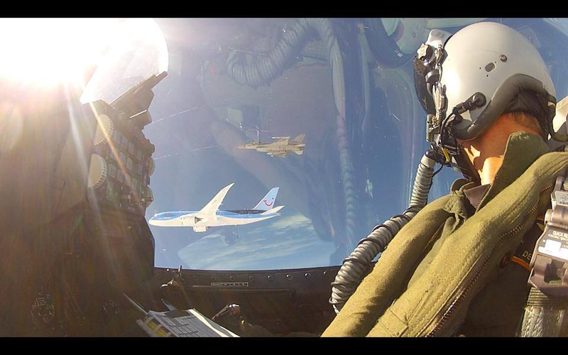 Illustration for article titled Extremely rare photo of two armed F-16s escorting a Boeing Dreamliner